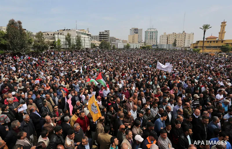 Palestinians, employed by the Palestinian Authority, chant slogans and wave placards during a demonstration against the decision to reduce their salaries in Gaza City on April 8, 2017. Photo by Ashraf Amra