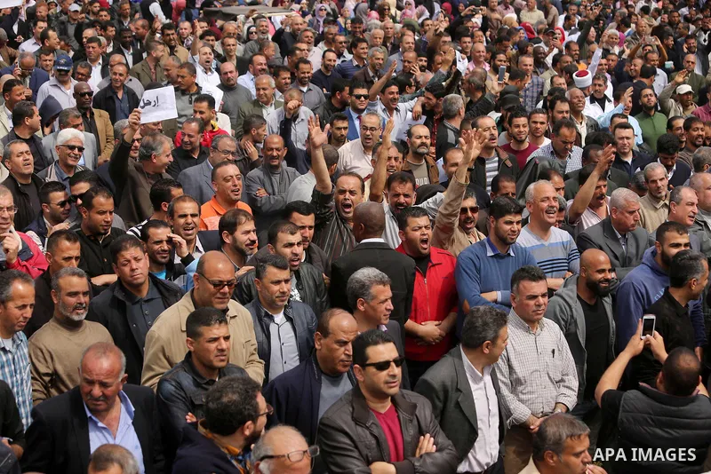 Palestinians, employed by the Palestinian Authority, chant slogans and wave placards during a demonstration against the decision to reduce their salaries in Gaza City on April 8, 2017. Photo by Ashraf Amra