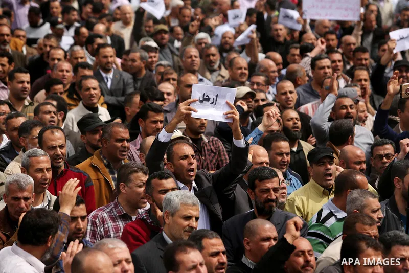 Palestinians, employed by the Palestinian Authority, chant slogans and wave placards during a demonstration against the decision to reduce their salaries in Gaza City on April 8, 2017. Photo by Ashraf Amra