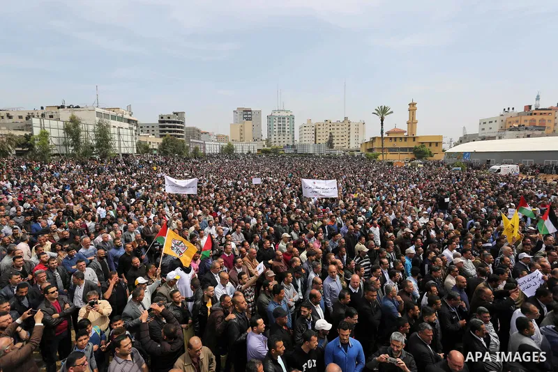 Palestinians, employed by the Palestinian Authority, chant slogans and wave placards during a demonstration against the decision to reduce their salaries in Gaza City on April 8, 2017. Photo by Ashraf Amra