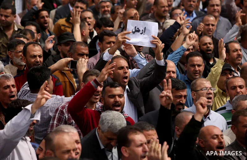 Palestinians, employed by the Palestinian Authority, chant slogans and wave placards during a demonstration against the decision to reduce their salaries in Gaza City on April 8, 2017. Photo by Ashraf Amra