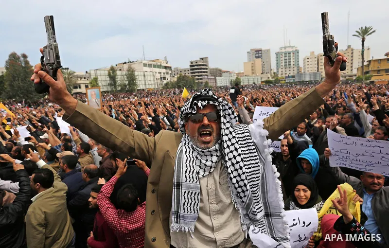 Palestinians, employed by the Palestinian Authority, chant slogans and wave placards during a demonstration against the decision to reduce their salaries in Gaza City on April 8, 2017. Photo by Ashraf Amra