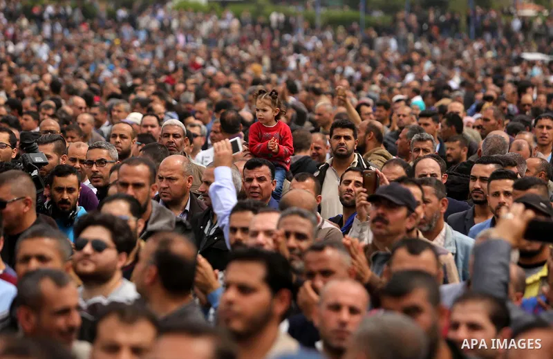 Palestinians, employed by the Palestinian Authority, chant slogans and wave placards during a demonstration against the decision to reduce their salaries in Gaza City on April 8, 2017. Photo by Ashraf Amra