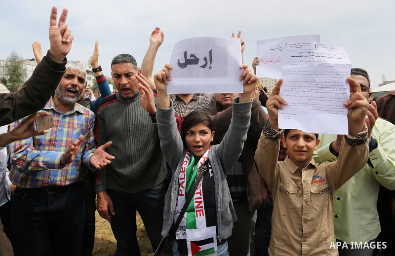 Palestinians, employed by the Palestinian Authority, chant slogans and wave placards during a demonstration against the decision to reduce their salaries in Gaza City on April 8, 2017. Photo by Ashraf Amra