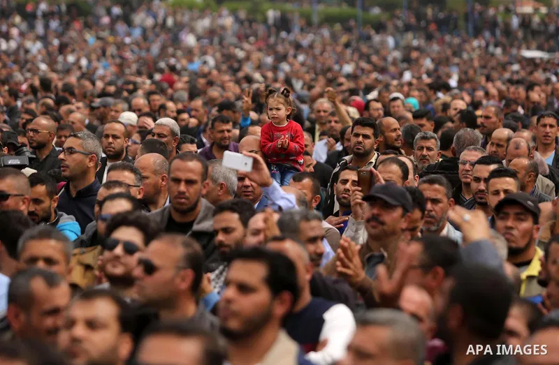 Palestinians, employed by the Palestinian Authority, chant slogans and wave placards during a demonstration against the decision to reduce their salaries in Gaza City on April 8, 2017. Photo by Ashraf Amra