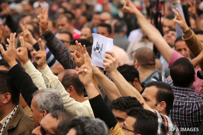 Palestinians, employed by the Palestinian Authority, chant slogans and wave placards during a demonstration against the decision to reduce their salaries in Gaza City on April 8, 2017. Photo by Ashraf Amra