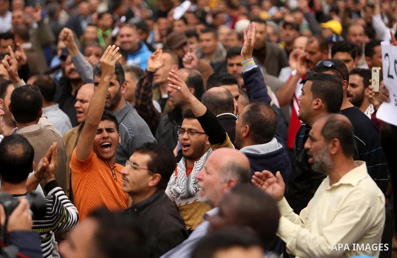 Palestinians, employed by the Palestinian Authority, chant slogans and wave placards during a demonstration against the decision to reduce their salaries in Gaza City on April 8, 2017. Photo by Ashraf Amra