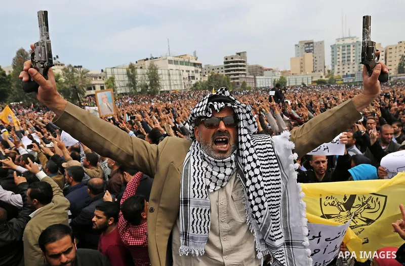 Palestinians, employed by the Palestinian Authority, chant slogans and wave placards during a demonstration against the decision to reduce their salaries in Gaza City on April 8, 2017. Photo by Ashraf Amra