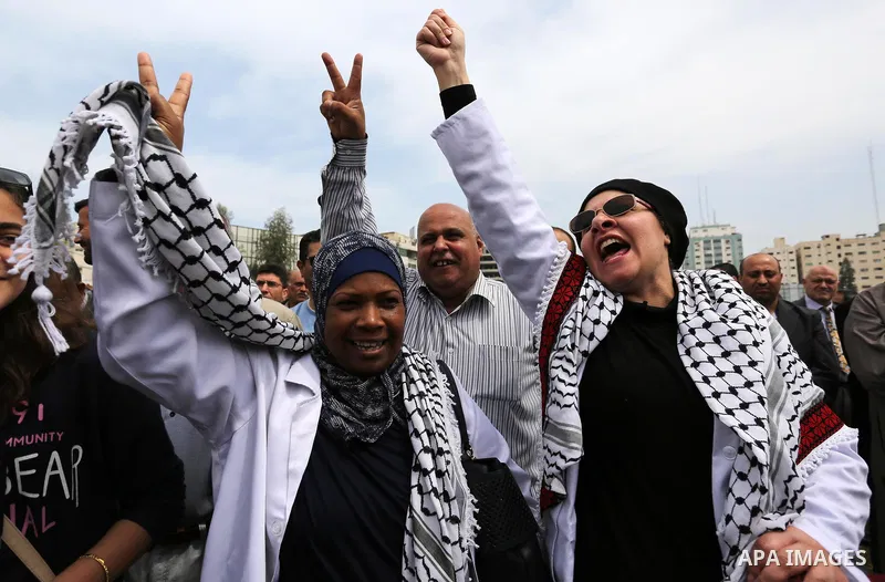 Palestinians, employed by the Palestinian Authority, chant slogans and wave placards during a demonstration against the decision to reduce their salaries in Gaza City on April 8, 2017. Photo by Ashraf Amra
