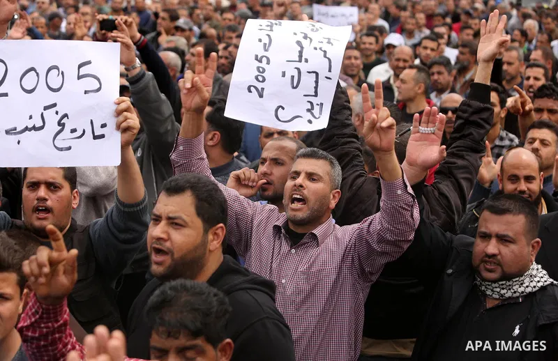 Palestinians, employed by the Palestinian Authority, chant slogans and wave placards during a demonstration against the decision to reduce their salaries in Gaza City on April 8, 2017. Photo by Ashraf Amra