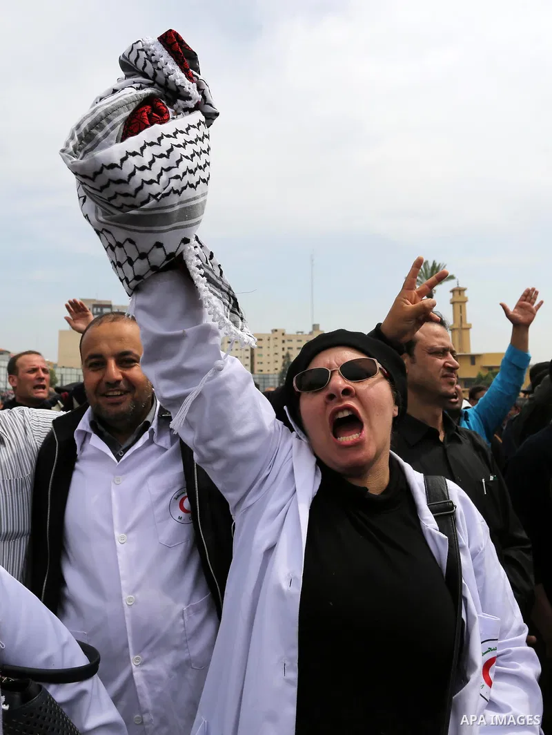 Palestinians, employed by the Palestinian Authority, chant slogans and wave placards during a demonstration against the decision to reduce their salaries in Gaza City on April 8, 2017. Photo by Ashraf Amra