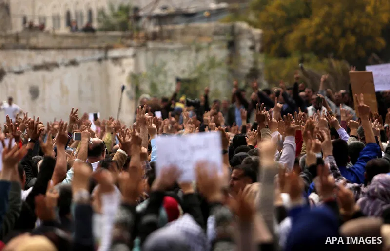 Palestinians, employed by the Palestinian Authority, chant slogans and wave placards during a demonstration against the decision to reduce their salaries in Gaza City on April 8, 2017. Photo by Ashraf Amra