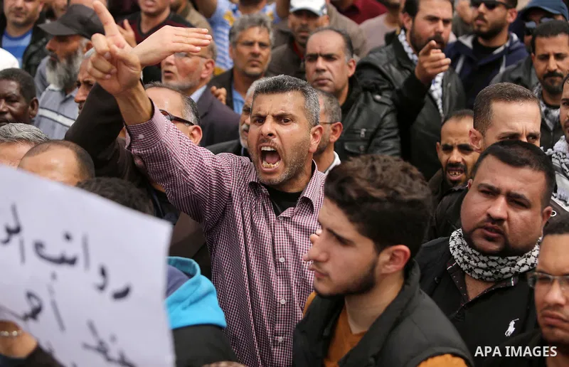 Palestinians, employed by the Palestinian Authority, chant slogans and wave placards during a demonstration against the decision to reduce their salaries in Gaza City on April 8, 2017. Photo by Ashraf Amra