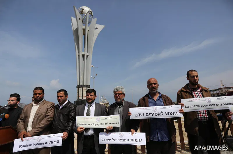 Palestinians hold placards during a protest to show solidarity with Palestinian prisoners held in Israeli Jails, in Gaza city, on April 9, 2017. Photo by Ashraf Amra