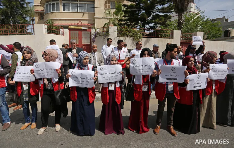 Palestinian doctors hold banners during a rally to mark the World Health Day, in Gaza city, on April 9, 2017. Photo by Ashraf Amra