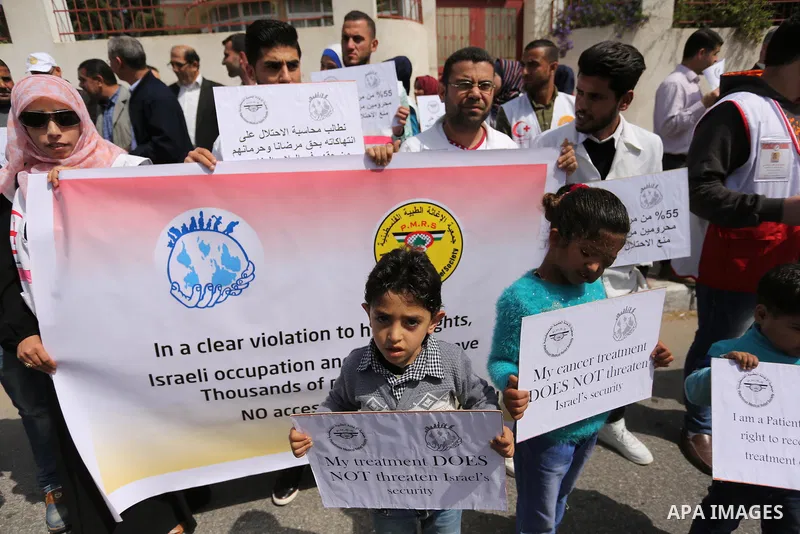 Palestinian doctors hold banners during a rally to mark the World Health Day, in Gaza city, on April 9, 2017. Photo by Ashraf Amra