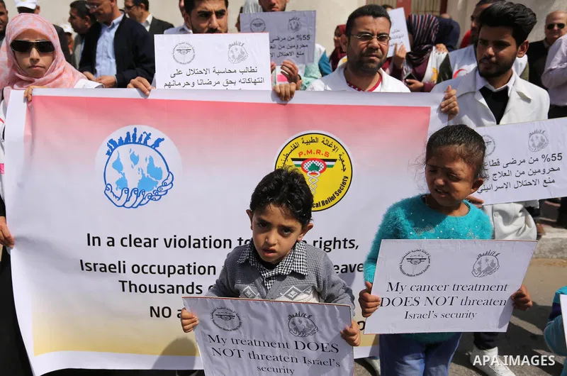Palestinian doctors hold banners during a rally to mark the World Health Day, in Gaza city, on April 9, 2017. Photo by Ashraf Amra
