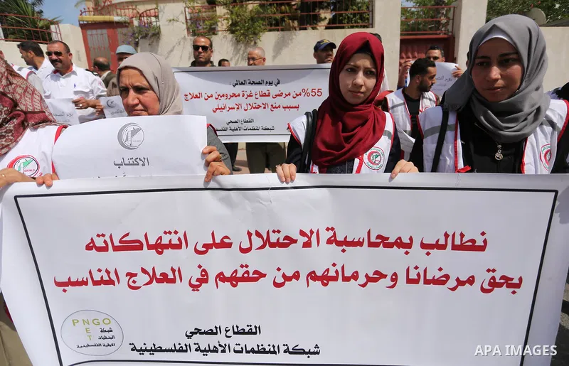 Palestinian doctors hold banners during a rally to mark the World Health Day, in Gaza city, on April 9, 2017. Photo by Ashraf Amra