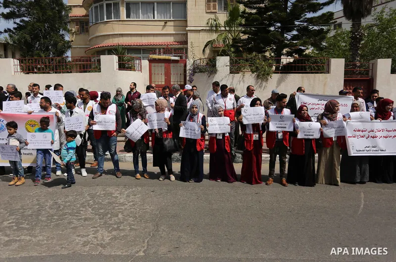 Palestinian doctors hold banners during a rally to mark the World Health Day, in Gaza city, on April 9, 2017. Photo by Ashraf Amra