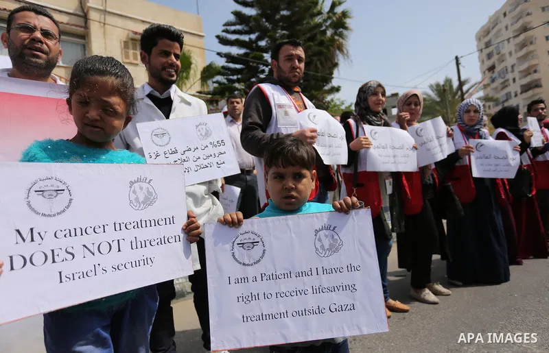 Palestinian doctors hold banners during a rally to mark the World Health Day, in Gaza city, on April 9, 2017. Photo by Ashraf Amra