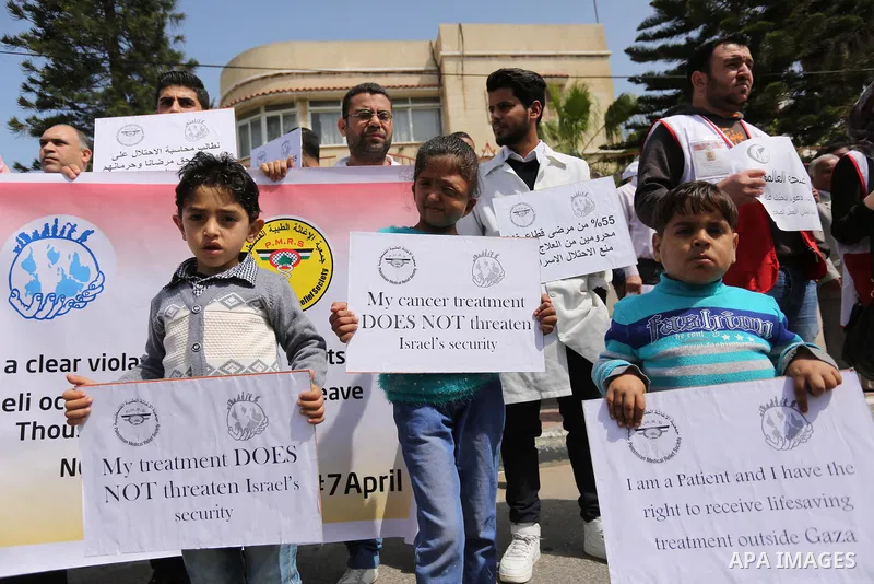 Palestinian doctors hold banners during a rally to mark the World Health Day, in Gaza city, on April 9, 2017. Photo by Ashraf Amra