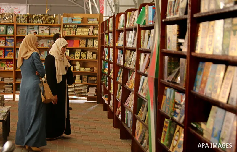 Palestinians browse through books on a stand at a book fair, in Gaza city on April 09, 2017. Photo by Ashraf Amra