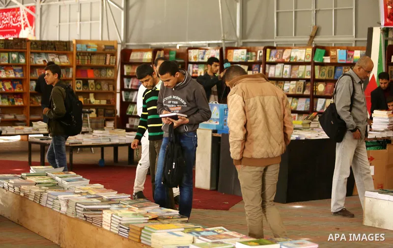 Palestinians browse through books on a stand at a book fair, in Gaza city on April 09, 2017. Photo by Ashraf Amra