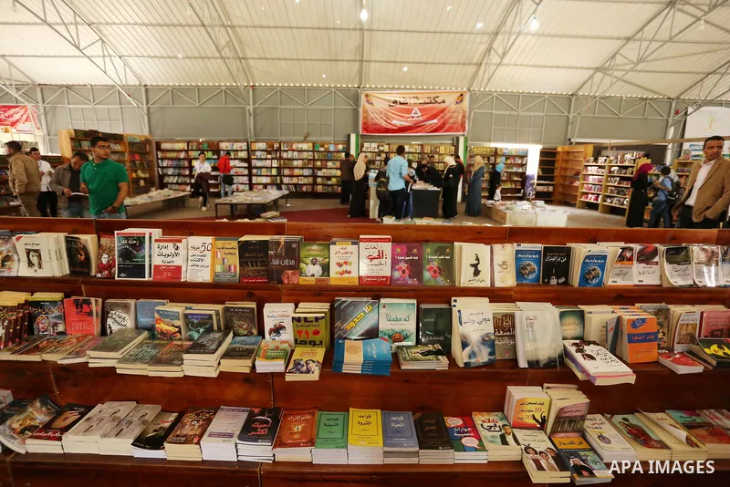 Palestinians browse through books on a stand at a book fair, in Gaza city on April 09, 2017. Photo by Ashraf Amra