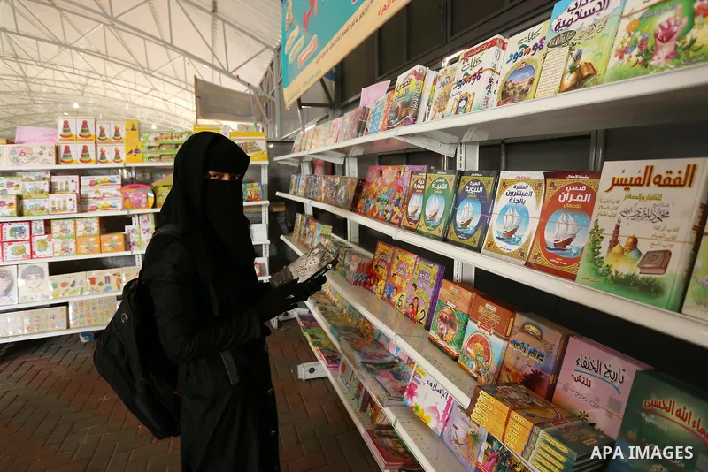 Palestinians browse through books on a stand at a book fair, in Gaza city on April 09, 2017. Photo by Ashraf Amra