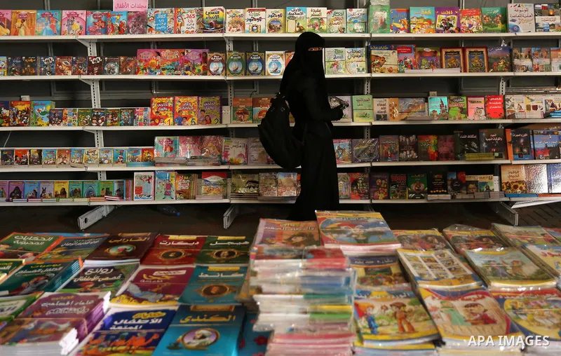Palestinians browse through books on a stand at a book fair, in Gaza city on April 09, 2017. Photo by Ashraf Amra