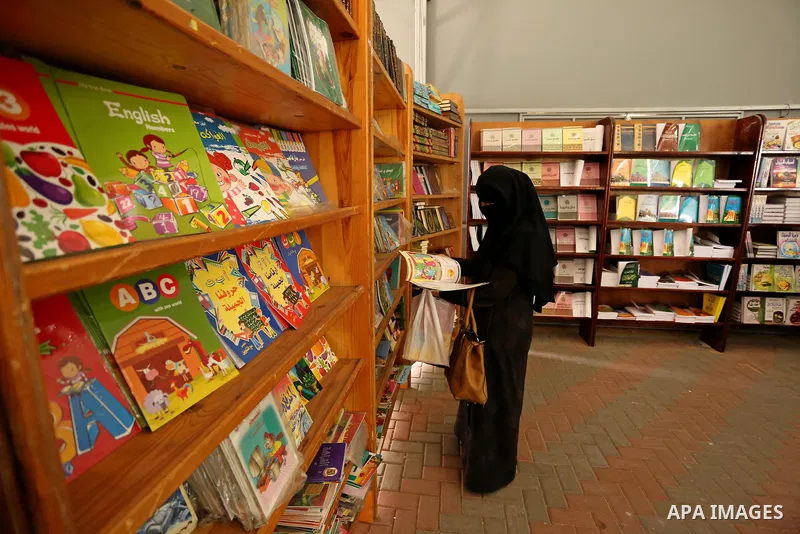 Palestinians browse through books on a stand at a book fair, in Gaza city on April 09, 2017. Photo by Ashraf Amra