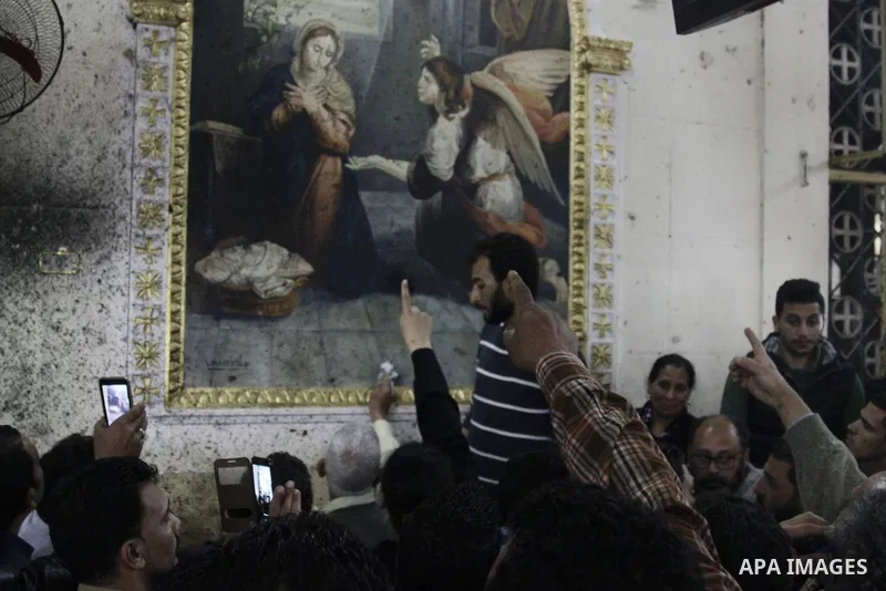 Relatives of a victim react inside the Mar Girgis Coptic Orthodox Church that was bombed on Sunday in the Nile Delta City of Tanta, 120 kilometres (75 miles) north of Cairo, at which a bomb blast struck worshippers gathe...