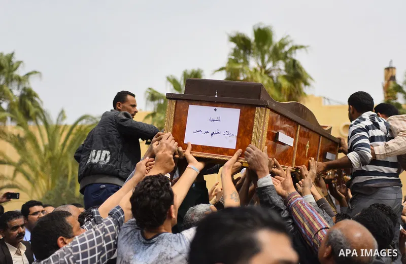 Mourners carry the coffin of one of the victims of the blast at the Coptic Christian Saint Mark's church in Alexandria the previous day during a funeral procession at the Monastery of Marmina in the city of Borg El-Arab,...