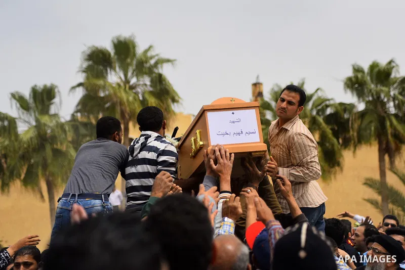 Mourners carry the coffin of one of the victims of the blast at the Coptic Christian Saint Mark's church in Alexandria the previous day during a funeral procession at the Monastery of Marmina in the city of Borg El-Arab,...
