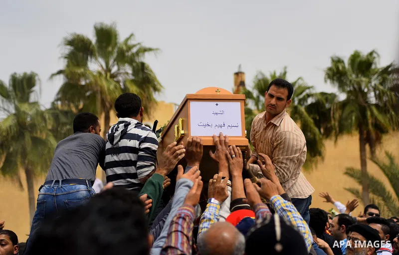 Mourners carry the coffin of one of the victims of the blast at the Coptic Christian Saint Mark's church in Alexandria the previous day during a funeral procession at the Monastery of Marmina in the city of Borg El-Arab,...