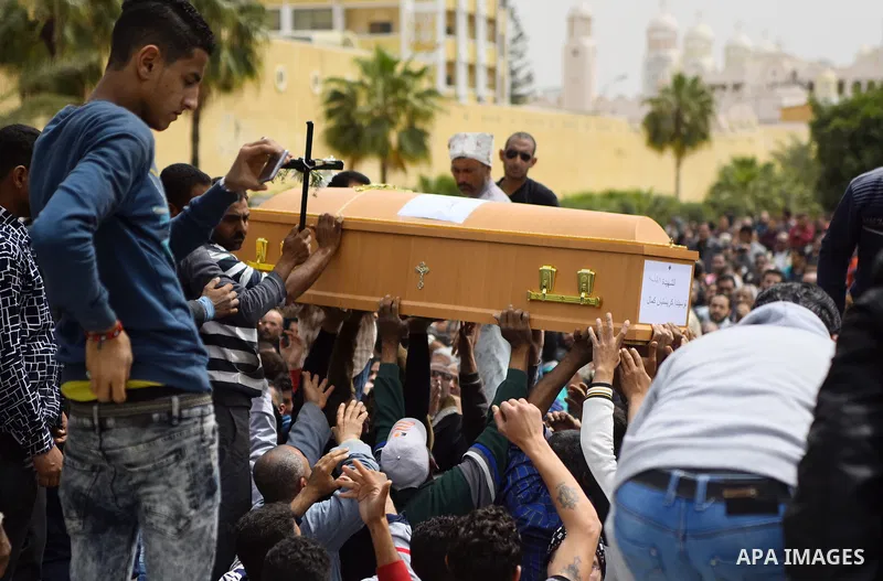 Mourners carry the coffin of one of the victims of the blast at the Coptic Christian Saint Mark's church in Alexandria the previous day during a funeral procession at the Monastery of Marmina in the city of Borg El-Arab,...