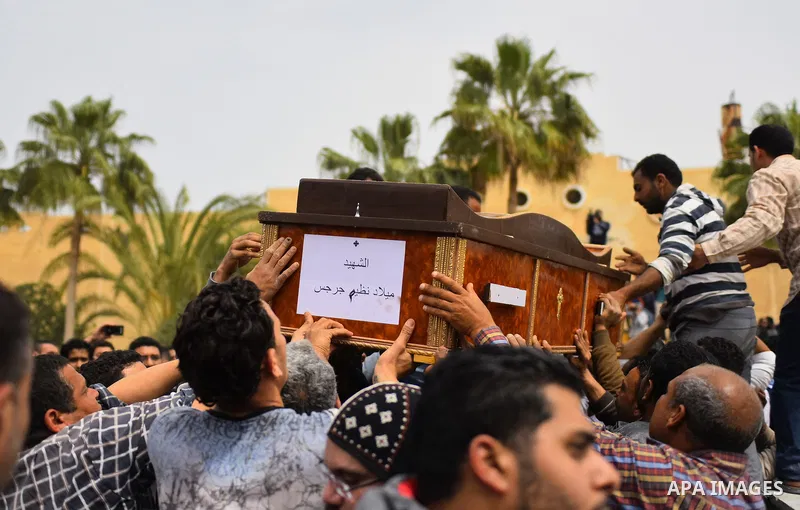 Mourners carry the coffin of one of the victims of the blast at the Coptic Christian Saint Mark's church in Alexandria the previous day during a funeral procession at the Monastery of Marmina in the city of Borg El-Arab,...