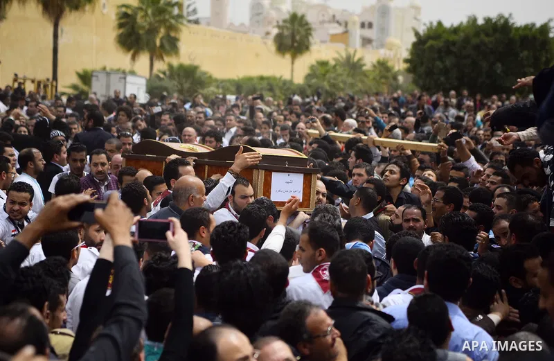 Mourners carry the coffins of the victims of the blast at the Coptic Christian Saint Mark's church in Alexandria the previous day during a funeral procession at the Monastery of Marmina in the city of Borg El-Arab, east...