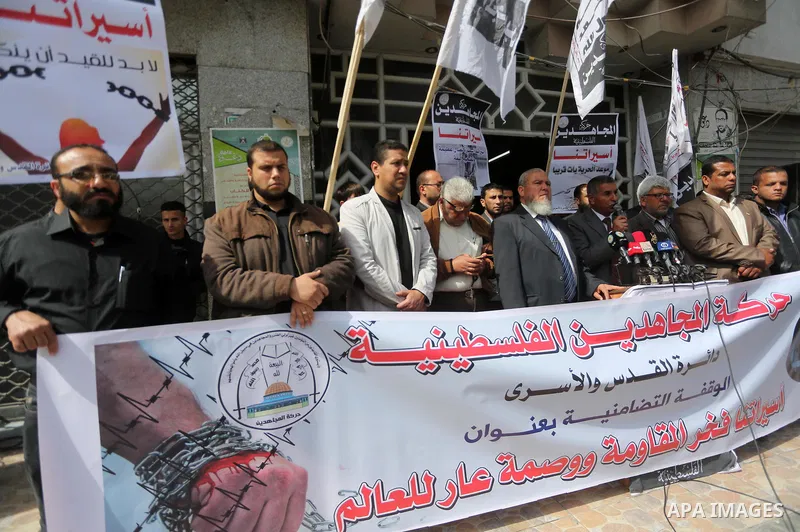 Palestinians hold placards during a protest to show solidarity with Palestinian prisoners held in Israeli Jails, in Gaza city, on April 11, 2017. Photo by Mohammed Asad