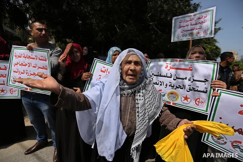 Palestinians employed by the Palestinian Authority, chant slogans and wave placards during a demonstration against the decision to reduce their salaries in Gaza City on April 11, 2017. Photo by Ashraf Amra