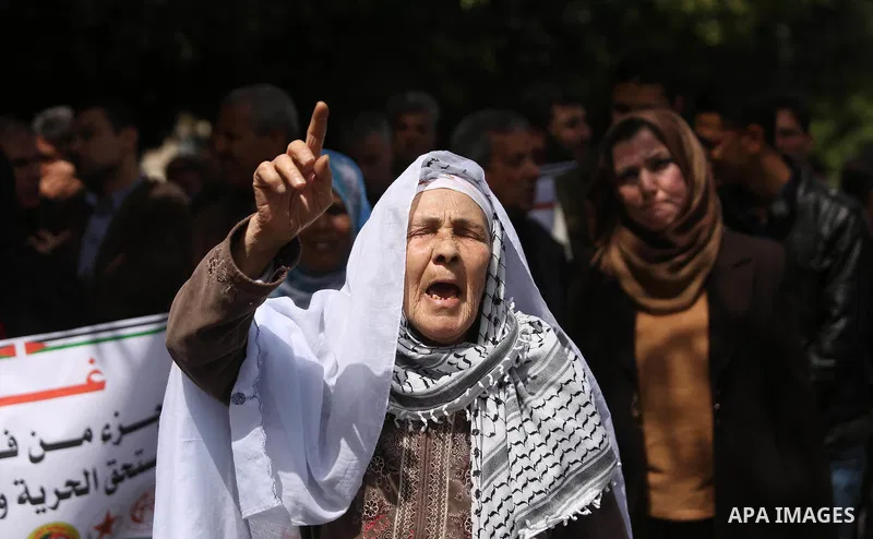 Palestinians employed by the Palestinian Authority, chant slogans and wave placards during a demonstration against the decision to reduce their salaries in Gaza City on April 11, 2017. Photo by Ashraf Amra