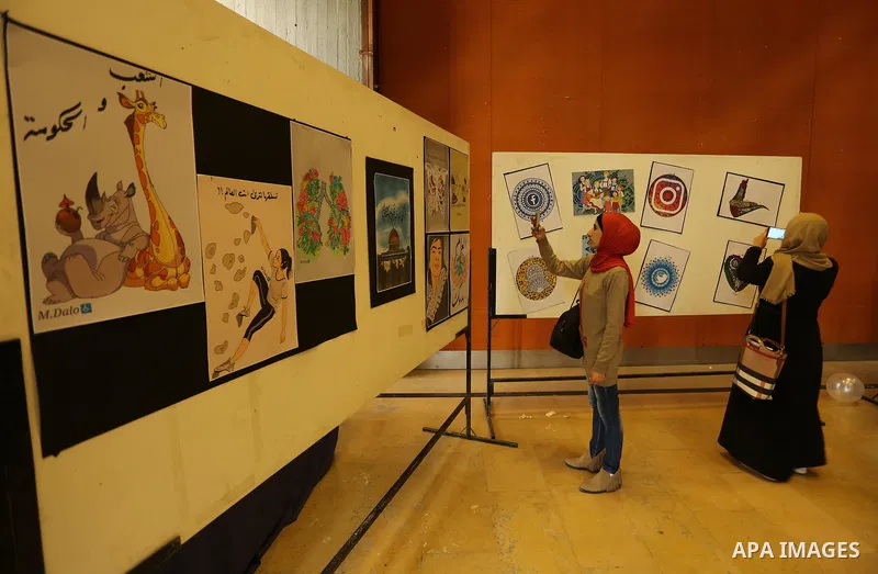 Palestinians attend the anime gallery for the disabled Mohammed Dalu, in Gaza city, on April 12, 2017. Photo by Ashraf Amra