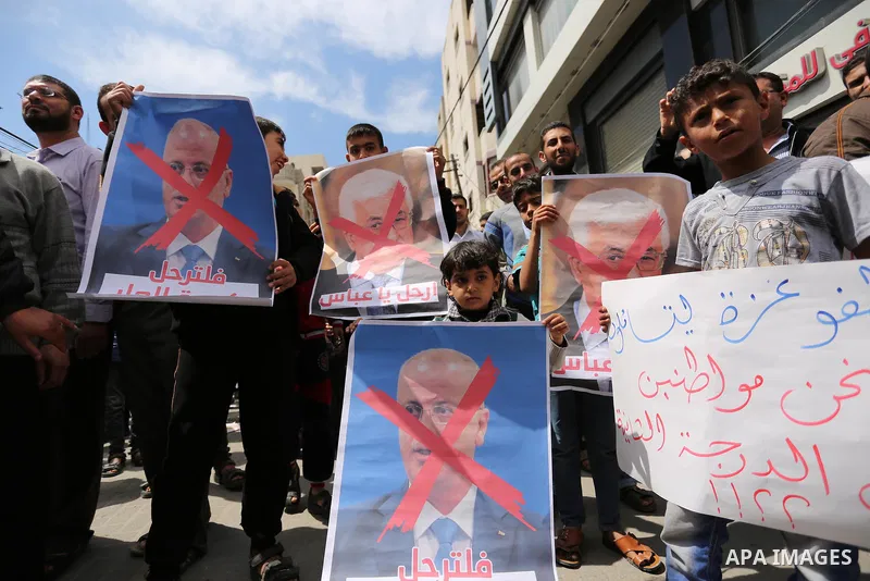 Hamas supporters hold crossed posters depicting Palestinian President Mahmoud Abbas and Palestinian Prime Minister Rami Hamdallah during a protest against them in Khan Younis in the southern Gaza Strip April 14, 2017. Ph...