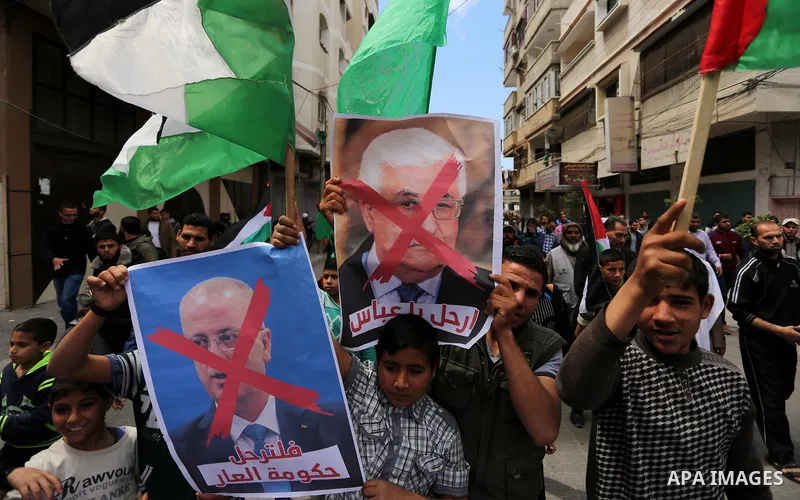 Hamas supporters hold crossed posters depicting Palestinian President Mahmoud Abbas and Palestinian Prime Minister Rami Hamdallah during a protest against them in Khan Younis in the southern Gaza Strip April 14, 2017. Ph...