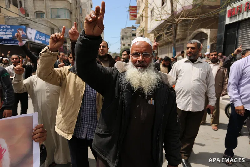 Hamas supporters hold crossed posters depicting Palestinian President Mahmoud Abbas and Palestinian Prime Minister Rami Hamdallah during a protest against them in Khan Younis in the southern Gaza Strip April 14, 2017. Ph...