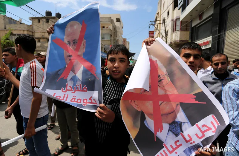 Hamas supporters hold crossed posters depicting Palestinian President Mahmoud Abbas and Palestinian Prime Minister Rami Hamdallah during a protest against them in Khan Younis in the southern Gaza Strip April 14, 2017. Ph...