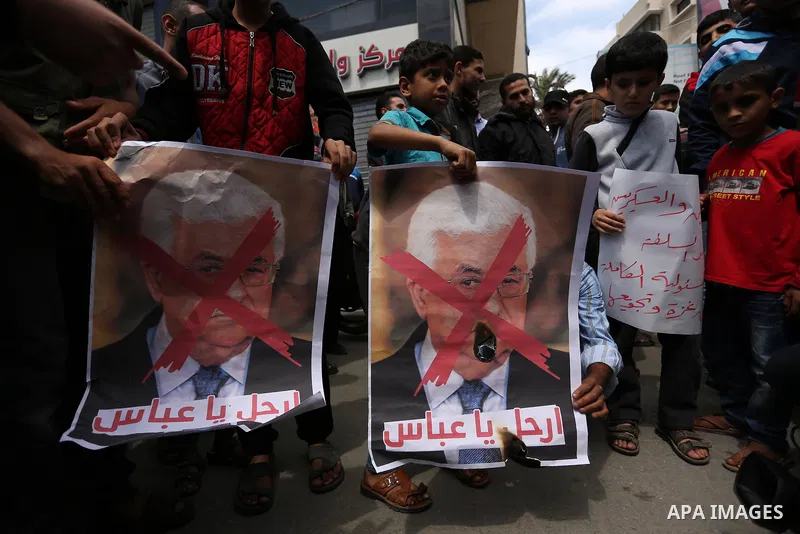 Hamas supporters hold crossed posters depicting Palestinian President Mahmoud Abbas and Palestinian Prime Minister Rami Hamdallah during a protest against them in Khan Younis in the southern Gaza Strip April 14, 2017. Ph...