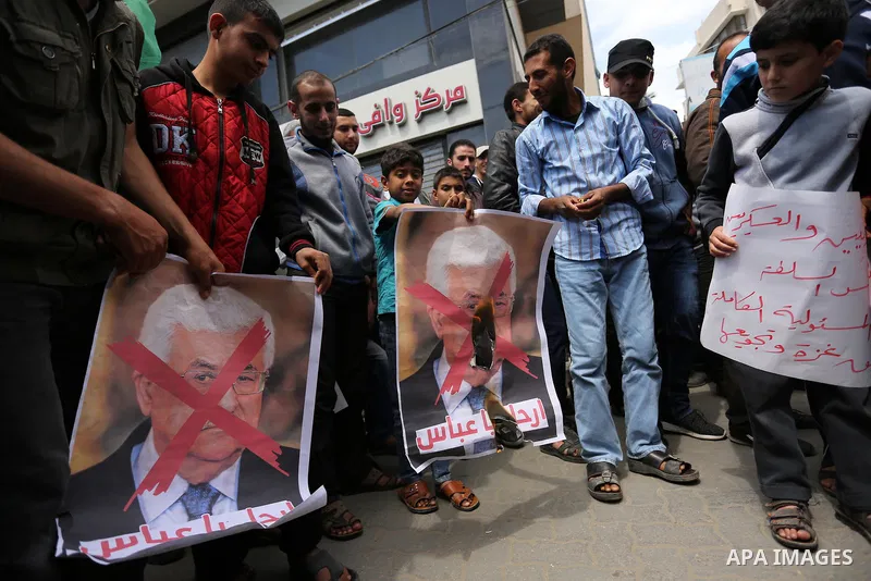 Hamas supporters hold crossed posters depicting Palestinian President Mahmoud Abbas and Palestinian Prime Minister Rami Hamdallah during a protest against them in Khan Younis in the southern Gaza Strip April 14, 2017. Ph...