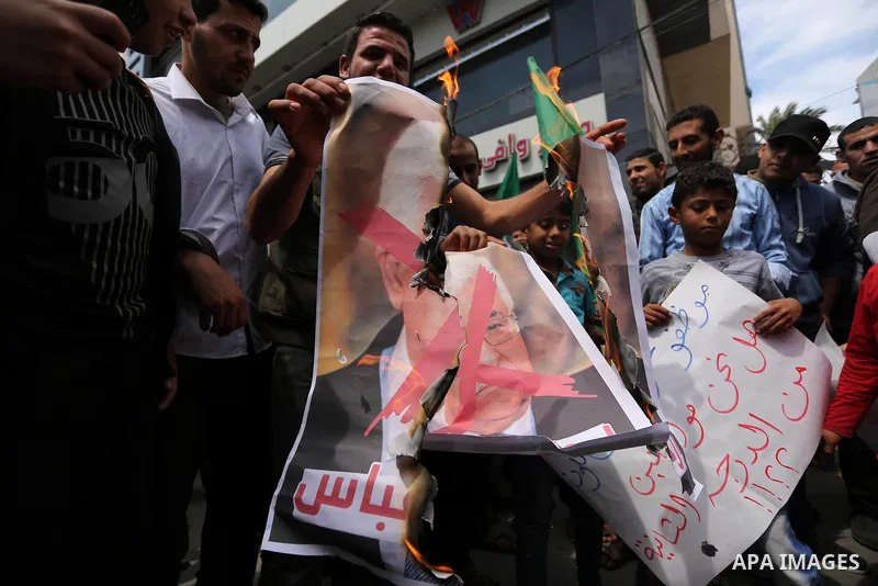 Hamas supporters hold crossed posters depicting Palestinian President Mahmoud Abbas and Palestinian Prime Minister Rami Hamdallah during a protest against them in Khan Younis in the southern Gaza Strip April 14, 2017. Ph...