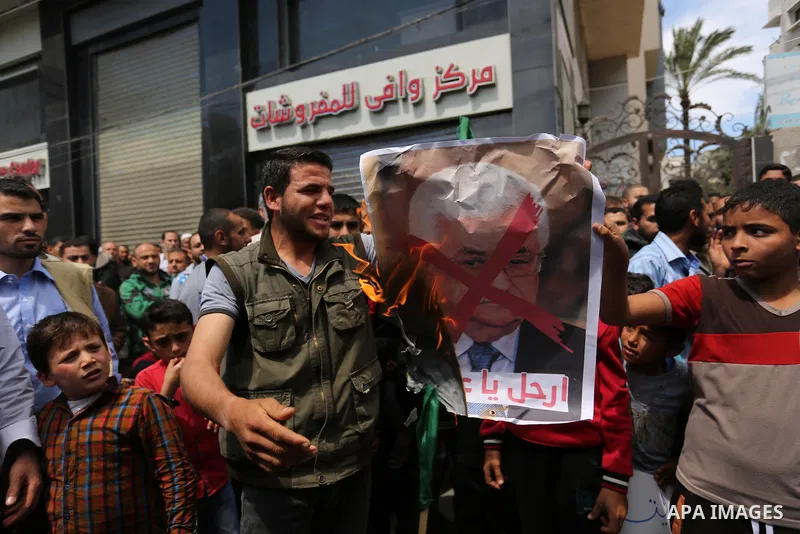 Hamas supporters hold crossed posters depicting Palestinian President Mahmoud Abbas and Palestinian Prime Minister Rami Hamdallah during a protest against them in Khan Younis in the southern Gaza Strip April 14, 2017. Ph...